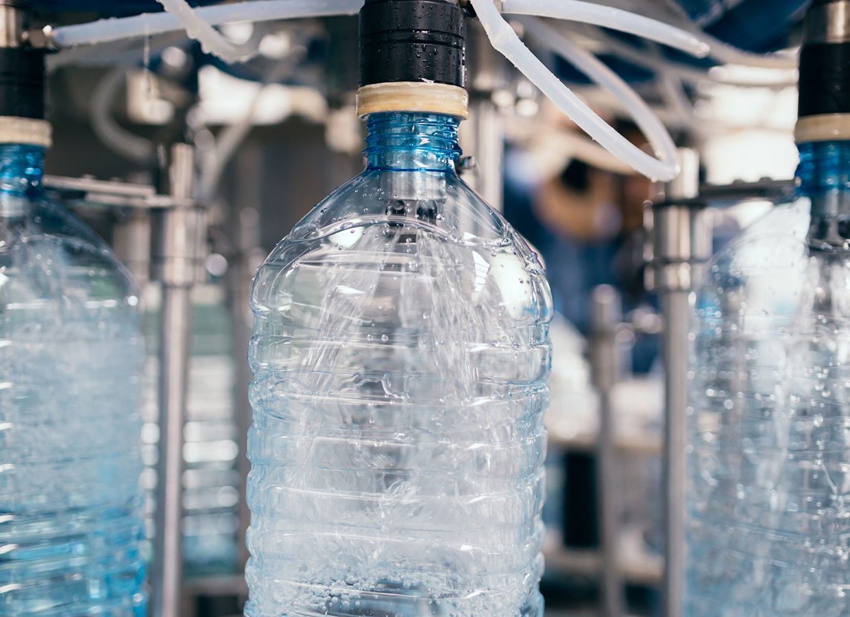 Robotic factory line for processing and bottling of pure spring water into canisters and bottles. Selective focus. Short depth of field.