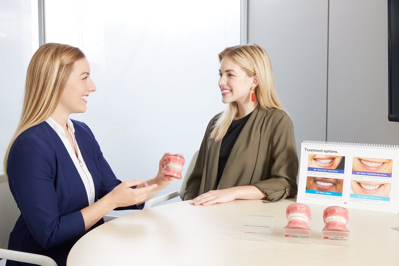 Nordic female patient in orthodontic consultation appointment for 3M™ Clarity™ Esthetic Orthodontic Solutions with treatment coordinator.