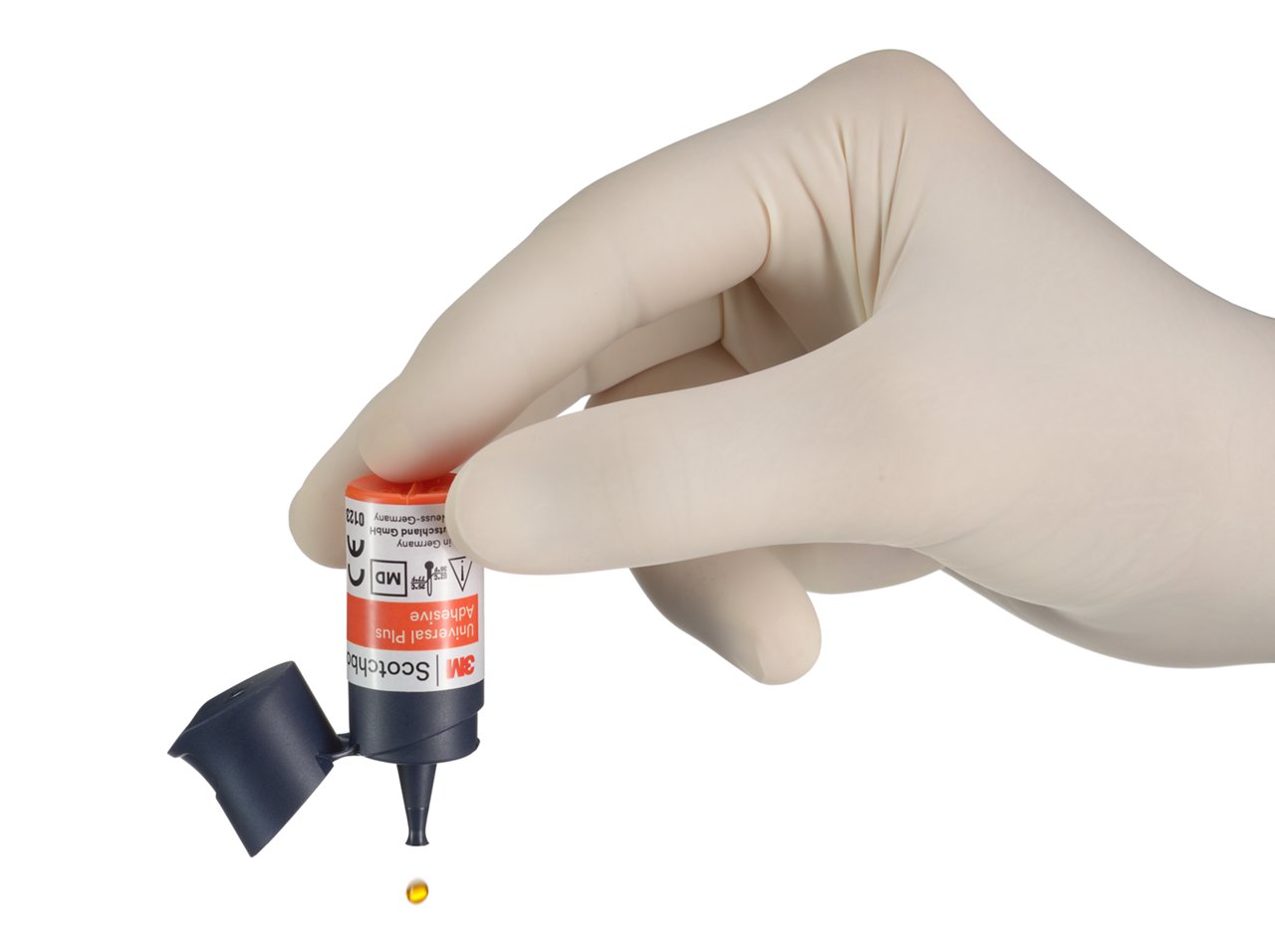 Vial de Adhesivo 3M Scotchbond Universal Plus en la mano con una gota cayendo
