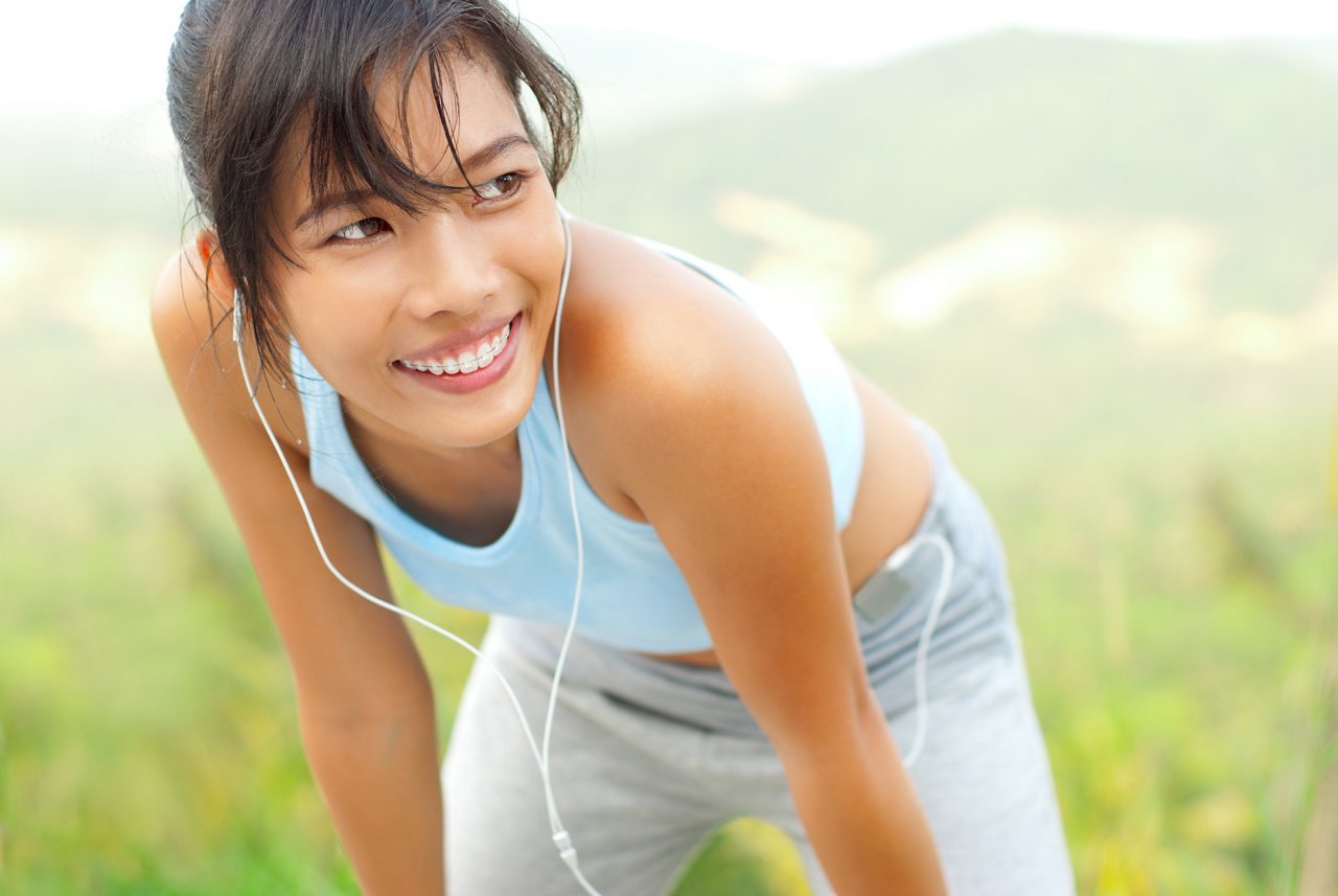 Beautiful smiling asian running woman resting in the nature.