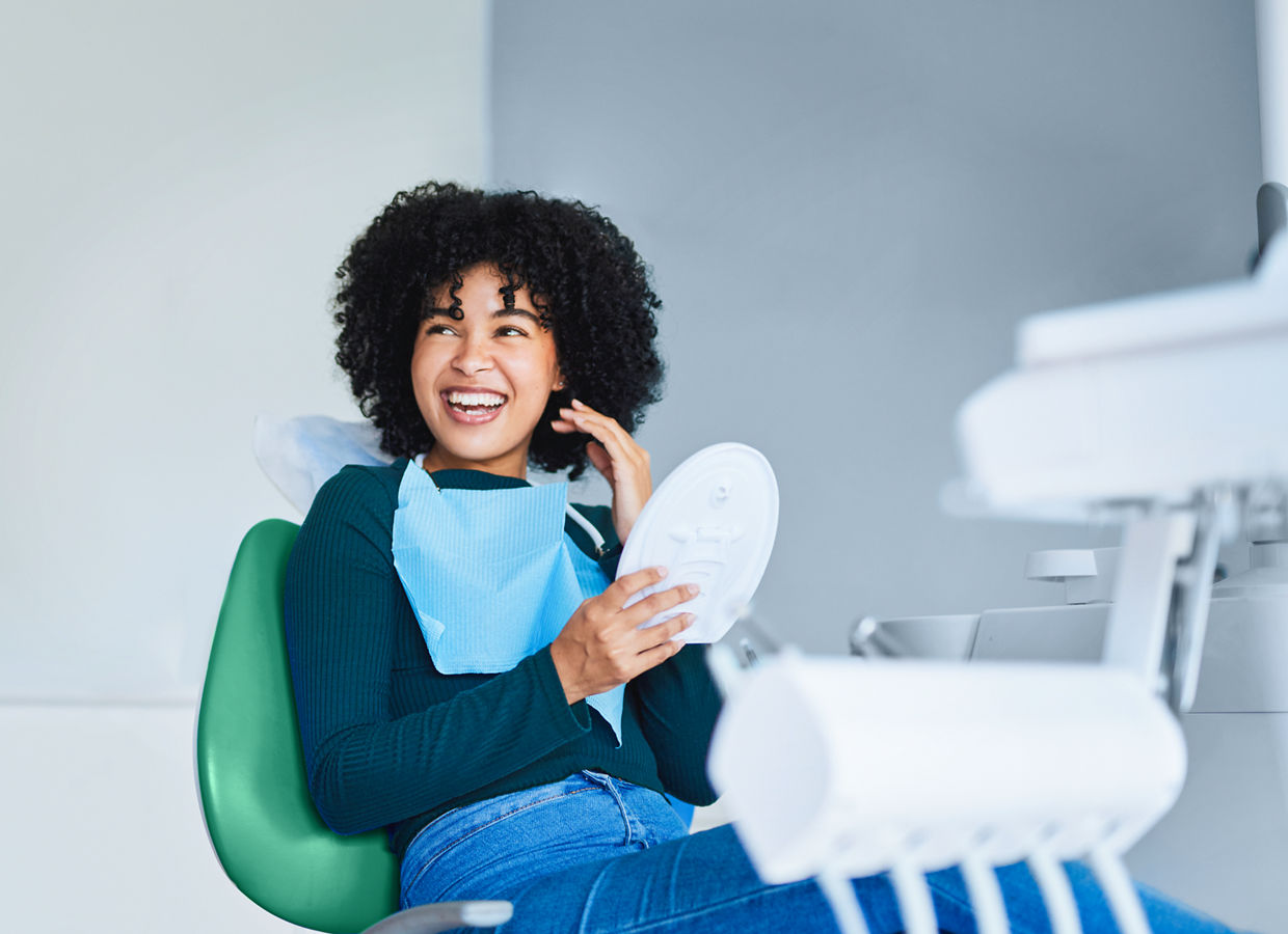Shot of a young woman admiring her teeth after having a dental procedure done