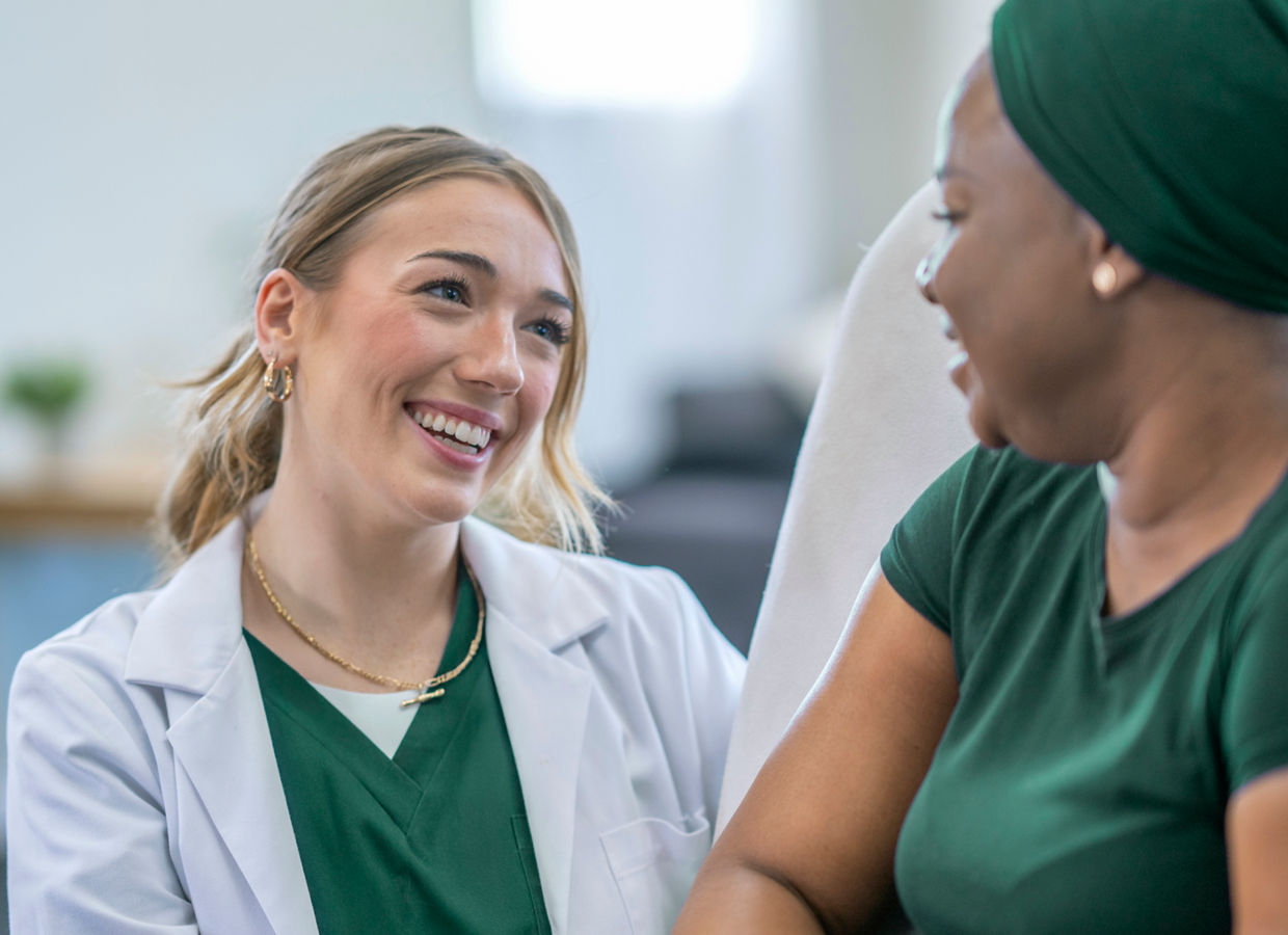 A female oncologist meets with her cancer patent in the comfort of her own home as she checks up on her between treatments.