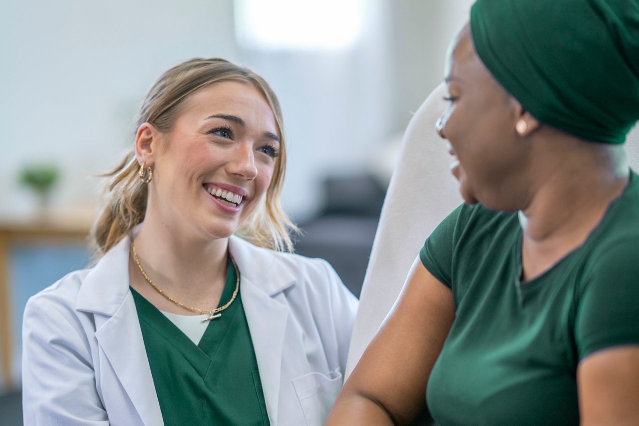 A female oncologist meets with her cancer patent in the comfort of her own home as she checks up on her between treatments.