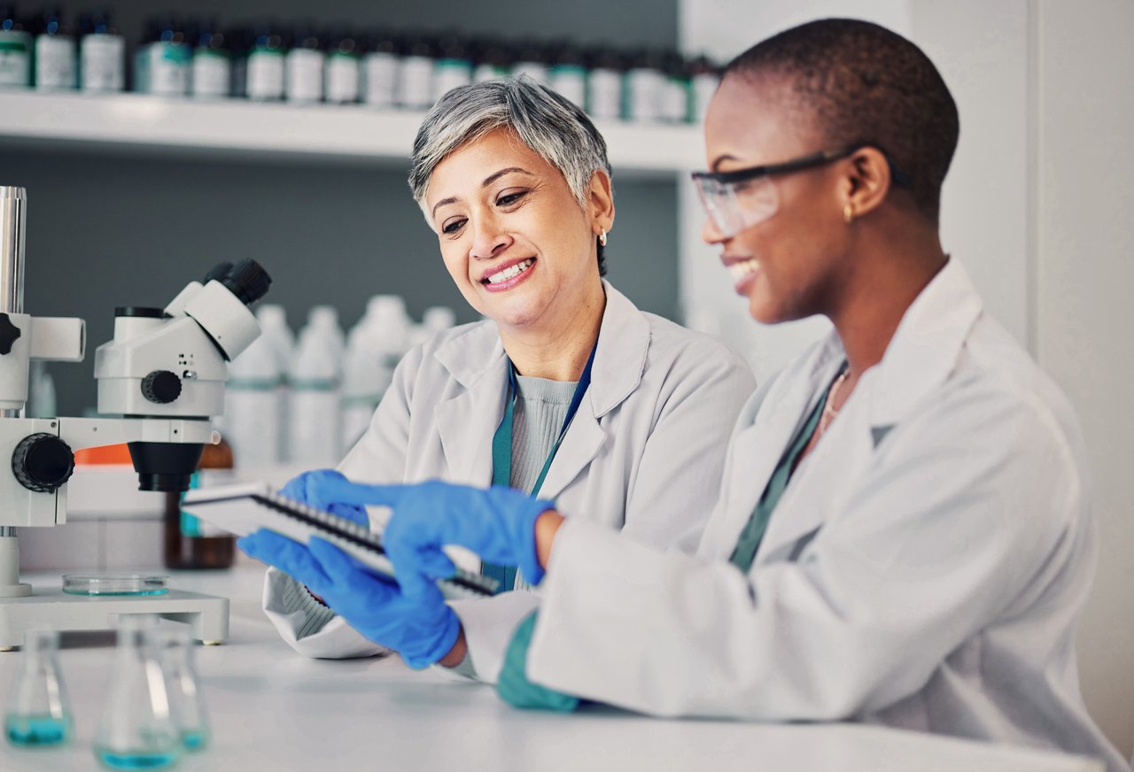 Two lab workers examining a notepad.