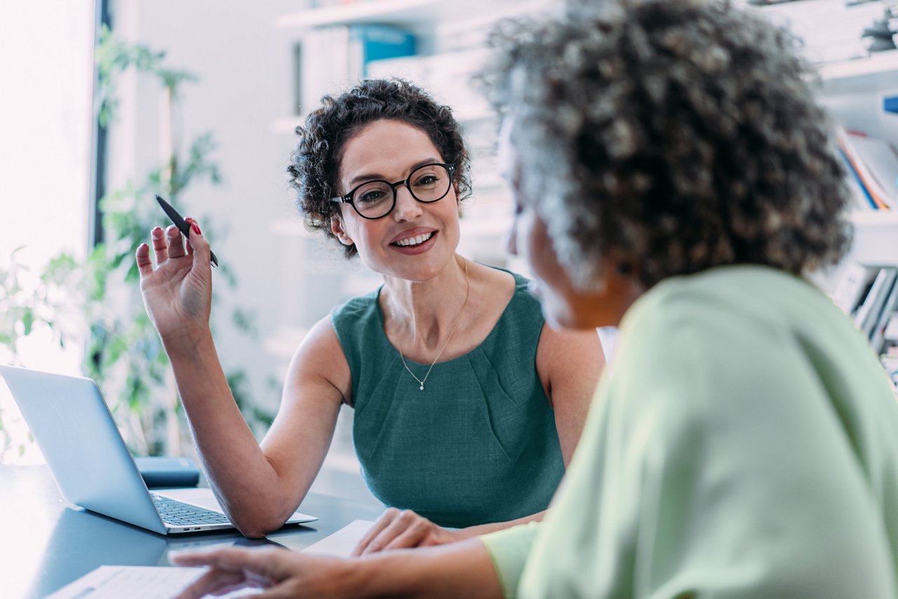 Two beautiful businesswomen sharing ideas during a meeting in the office.