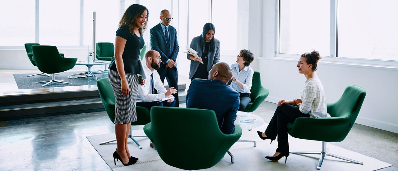 Image de plusieurs professionnels en plein échange dans un bureau ouvert.