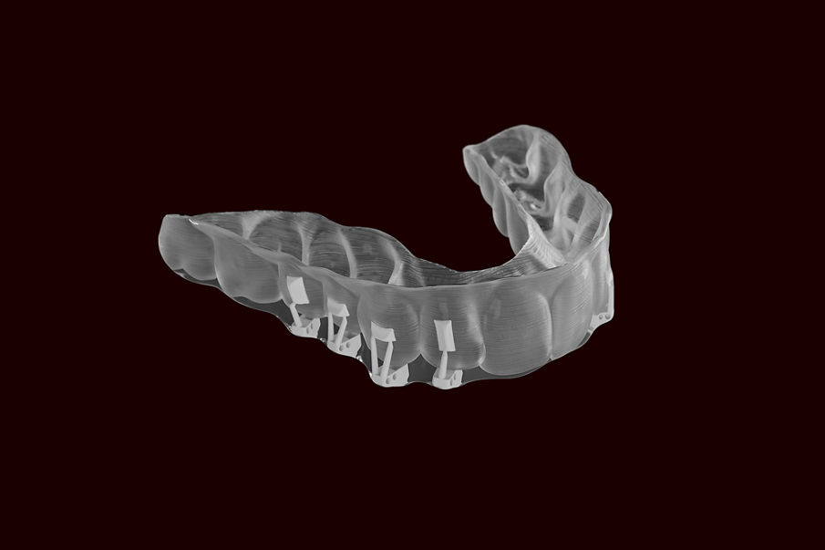 Grip product image on black background. 3D-printed Clarity Precision Grip Attachment tray, fully cured, pre-loaded, flash-less.