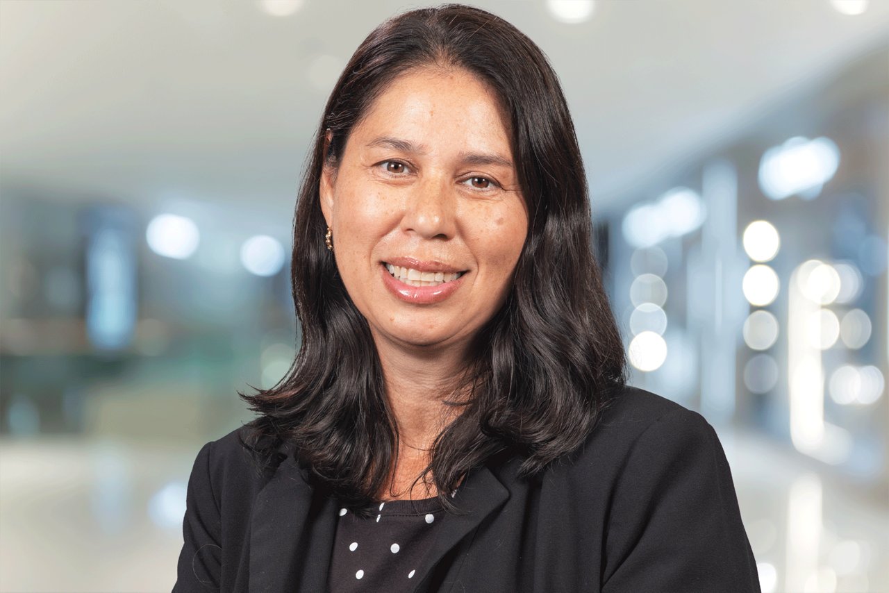 Headshot of Patricia Saleeby smiling and wearing a black blazer with an office setting background.