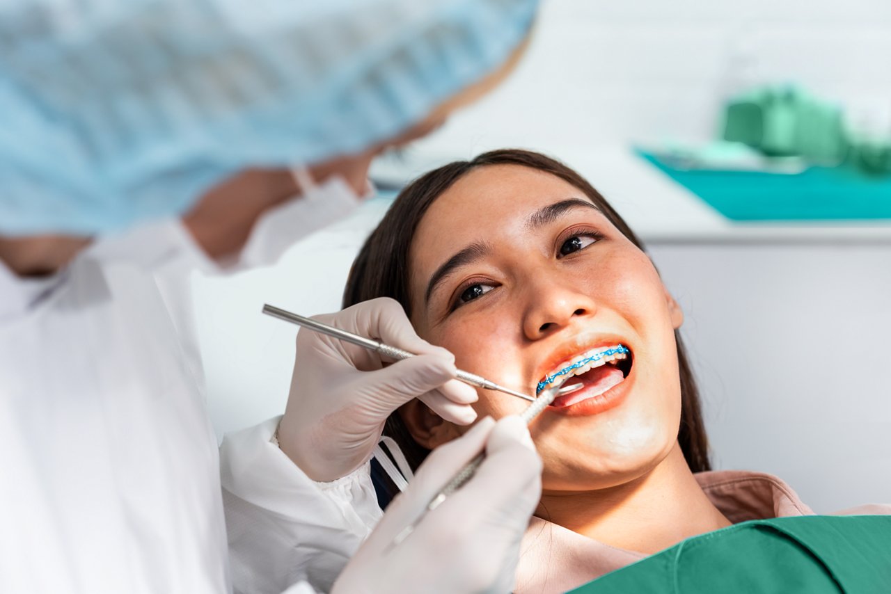 An ortho assistnat working on a female orthodontic patient in an office
