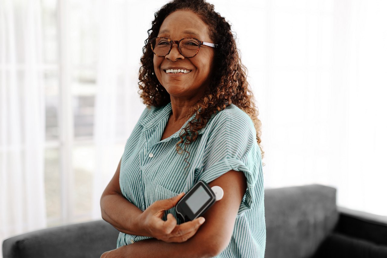 Female patient checking her transdermal patch with a flash glucose monitor to measure her blood sugar levels with a simple scan.