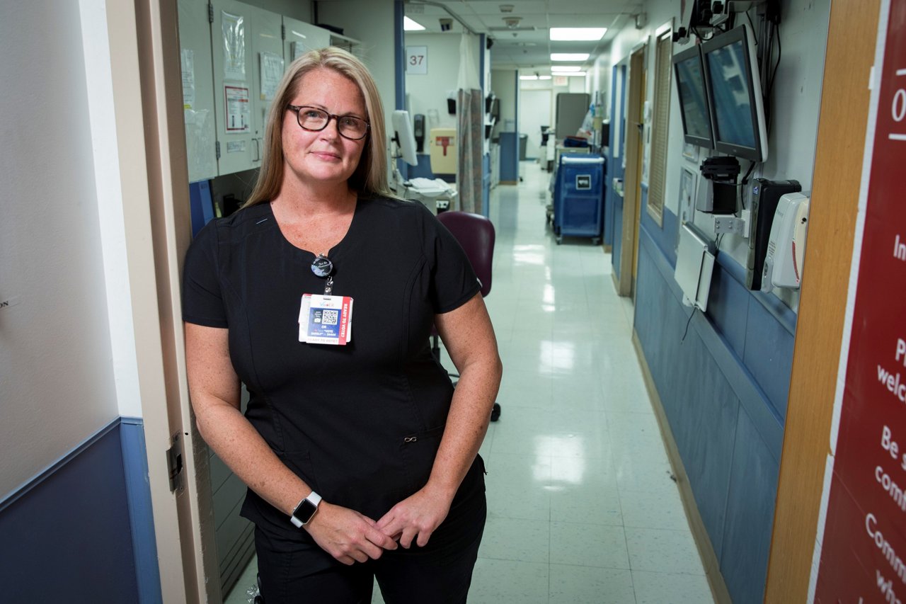 Nurse Tara White in black scrubs standing in a hospital hallway